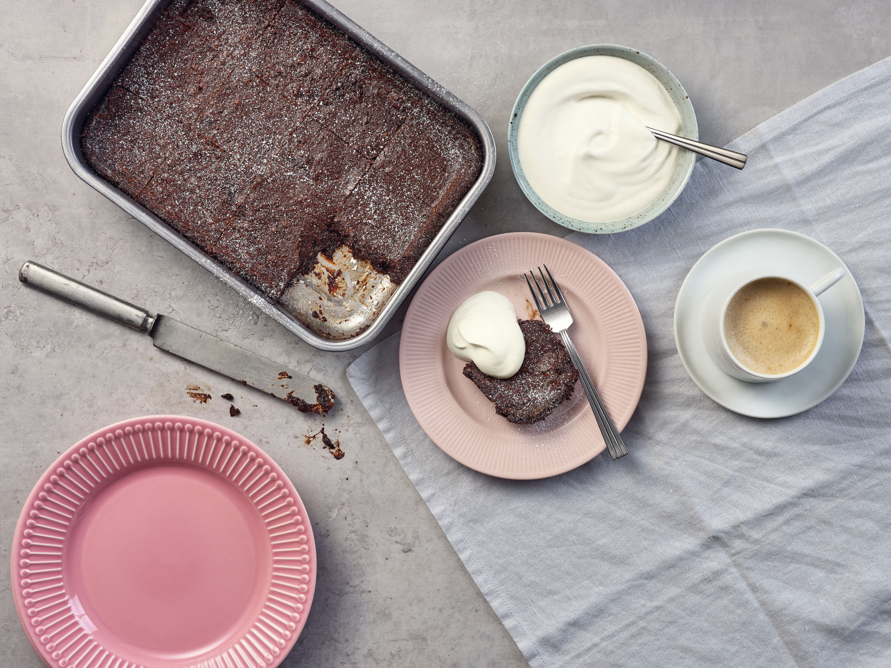 hasselnötsbrownie på tallrik och form med grädde