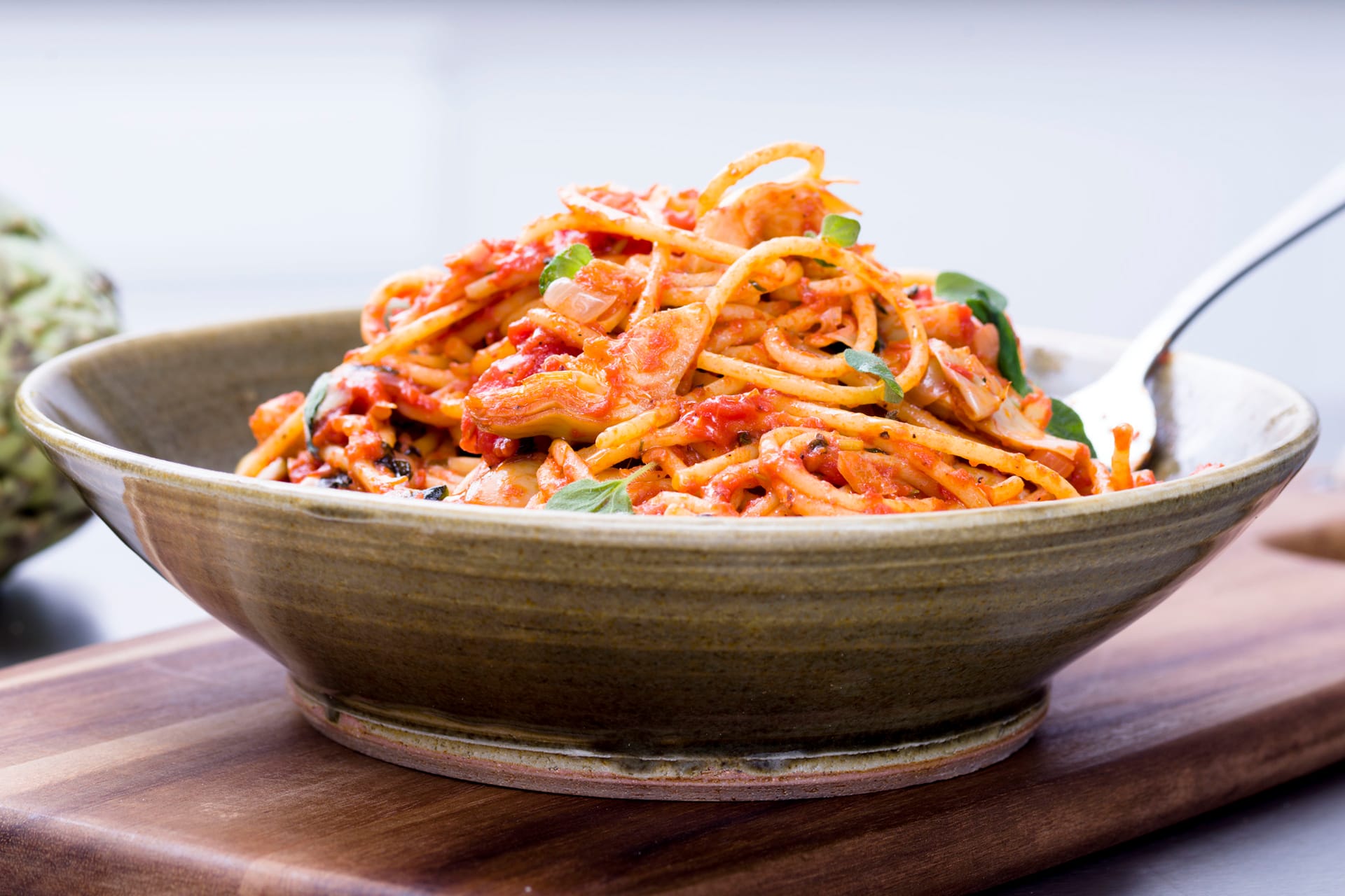 Tallrik med spaghetto med tomat och kronärtskockort